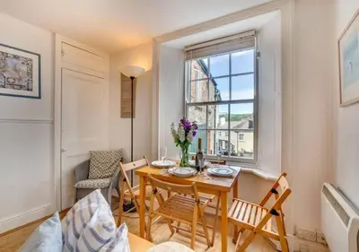 a dining room with a table and chairs and a window at Sundance Cottage Central Fowey with Sea Views in Fowey