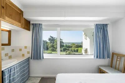 a bedroom with a bed and a window and a tub at Spacious Apartment in Rock Private Parking in Roche