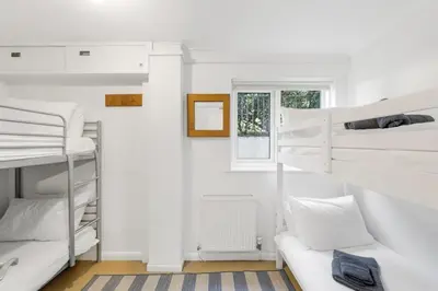 a room with white bunk beds and a couch at Spacious Apartment in Rock Private Parking in Roche