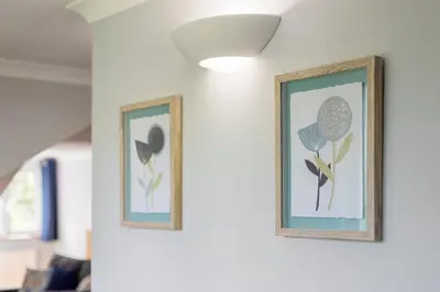 two framed pictures of flowers on a wall at Spacious Flat A Few Mins Walk to Carlyon Bay Beach in Carlyon Bay