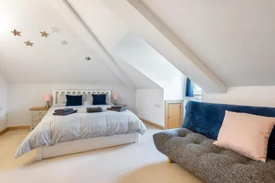 a bedroom with a bed and a couch at Spacious Flat A Few Mins Walk to Carlyon Bay Beach in Carlyon Bay
