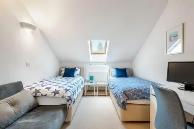 a room with two beds and a couch and a tv at Spacious Flat A Few Mins Walk to Carlyon Bay Beach in Carlyon Bay