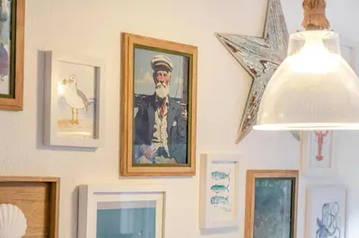 a wall with framed pictures of a man and a bird at 2 Bed in Carbis Bay oc-h34810 in Carbis Bay