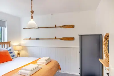 a bedroom with a bed and two wooden oars on the wall at 2 Bed in Carbis Bay oc-h34810 in Carbis Bay