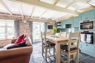 a kitchen and dining room with a table and chairs at 2 Bedroom Cottage Close to Perranporth Beach in Roche