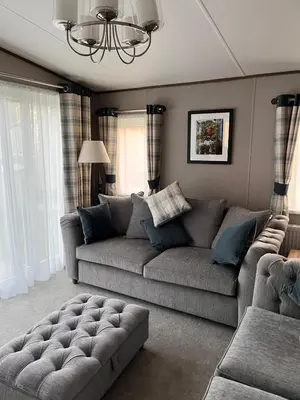 a living room with a gray couch and a chandelier at St Minver Hideaway in Saint Minver
