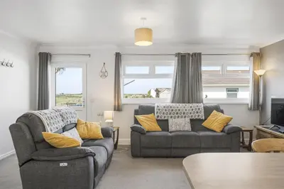 a living room with two chairs and a couch at Beach House & Garden in St Merryn Private Parking in St Merryn