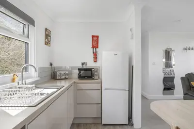 a white kitchen with a refrigerator and a sink at Beach House & Garden in St Merryn Private Parking in St Merryn