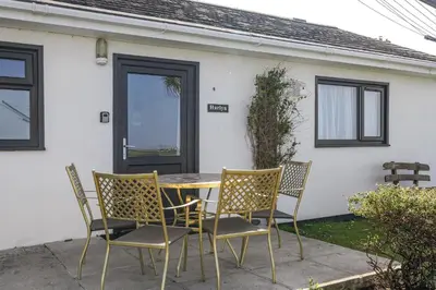 a table and chairs in front of a house at Beach House & Garden in St Merryn Private Parking in St Merryn