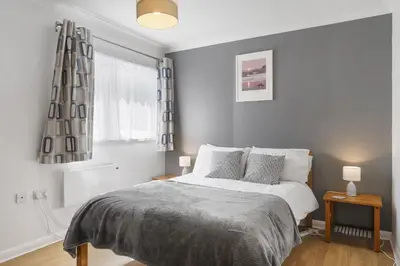 a white bedroom with a bed and a window at Beach House & Garden in St Merryn Private Parking in St Merryn