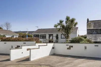 a house with white walls and stairs in a driveway at Beach House & Garden in St Merryn Private Parking in St Merryn