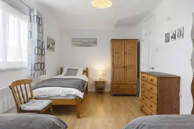 a bedroom with two beds and a dresser at Beach House & Garden in St Merryn Private Parking in St Merryn