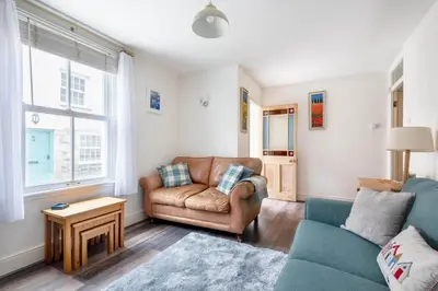 a living room with a couch and a chair at Gin O'Clock Mevagissey Level Walk to Harbour in Mevagissey