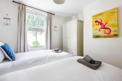 two white beds in a bedroom with a window at Gin O'Clock Mevagissey Level Walk to Harbour in Mevagissey