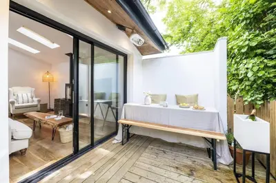 a room with a bed and a table on a patio at Beautiful Home in Heart of Truro in Truro