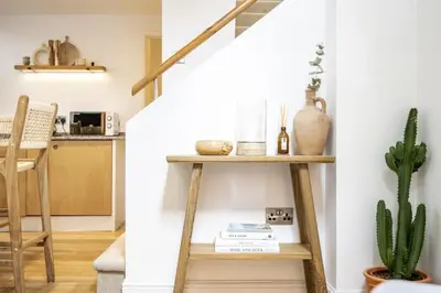 a living room with a wooden shelf and a cactus at Beautiful Home in Heart of Truro in Truro