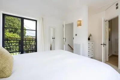a white bedroom with a large bed and a window at Beautiful Home in Heart of Truro in Truro