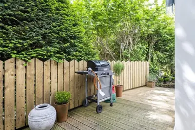 a grill sitting on a deck next to a fence at Beautiful Home in Heart of Truro in Truro