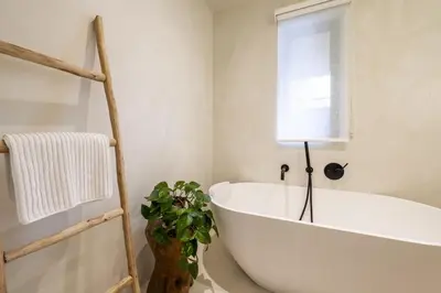a white bath tub in a bathroom with a plant at Beautiful Home in Heart of Truro in Truro