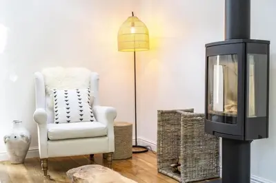 a living room with a white chair and a lamp at Beautiful Home in Heart of Truro in Truro