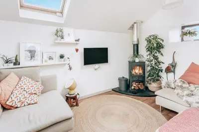 a living room with a couch and a fireplace at Romantic Converted Barn Perfect St Agnes Location in St. Agnes