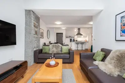 a living room with a couch and a table at Bright Flat with Estuary Views & Parking Falmouth in Falmouth