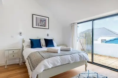 a bedroom with a bed and a large window at Bright Flat with Estuary Views & Parking Falmouth in Falmouth