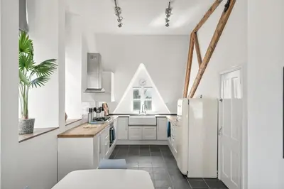 a kitchen with white cabinets and a white refrigerator at Penthouse Apartment with Sea Views Falmouth in Falmouth