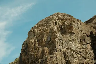 a rocky mountain with a blue sky in the background at 19th Century Cottage & Garden Private Parking in Perranporth