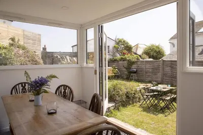 a dining room with a table and a large window at Cottage & Boatshed in Gorran Haven Private Parking in Gorran Haven