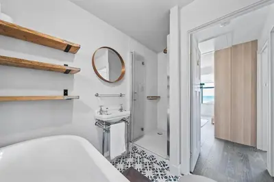 a white bathroom with a sink and a mirror at Beach House with Stunning Sea Views in Portreath
