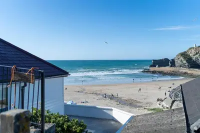 a beach with a group of people on the sand at Beach House with Stunning Sea Views in Portreath