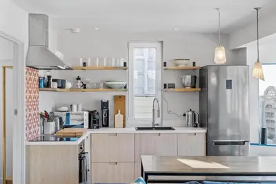 a kitchen with a stainless steel refrigerator and a table at Beach House with Stunning Sea Views in Portreath
