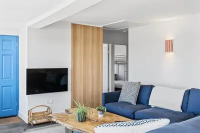 a living room with a blue couch and a table at Beach House with Stunning Sea Views in Portreath