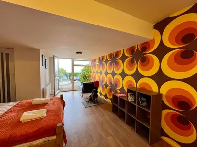 a bedroom with a bed and a colorful wall at Retro Ocean View Pad by Fistral Beach in Newquay