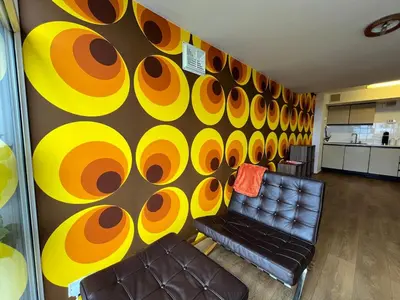 a living room with a wall with orange and yellow circles at Retro Ocean View Pad by Fistral Beach in Newquay