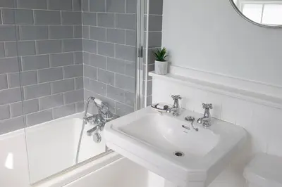 a white bathroom with a sink and a shower at Old Cottage 1 min from the sea! Crackington Haven in Crackington Haven