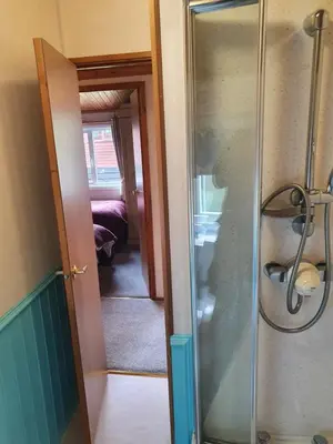 a bathroom with a shower with a glass door at The Retreat in Polperro