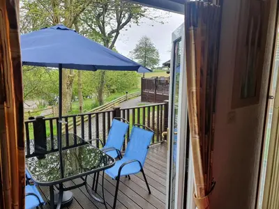 a balcony with a table and chairs and an umbrella at The Retreat in Polperro