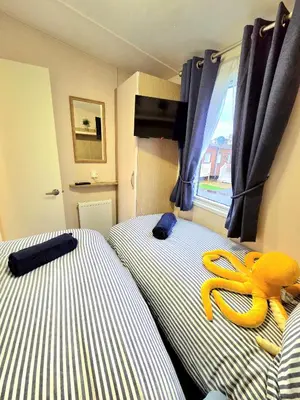 a hotel room with two beds with a stuffed octopus on them at The Crab Shack in Tywardreath