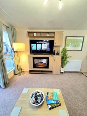 a living room with a tv and a table at The Crab Shack in Tywardreath