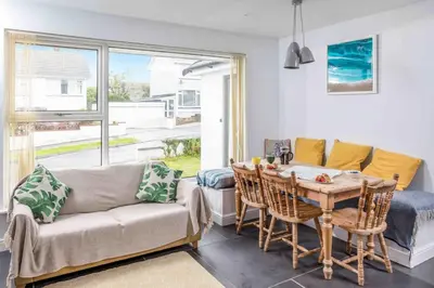 a living room with a couch and a table at Parkland Place - Spacious Newquay family holiday home, parking, log burner, dog friendly in Saint Columb Minor