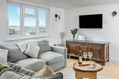 a living room with a couch and a tv at Parkland Place - Spacious Newquay family holiday home, parking, log burner, dog friendly in Saint Columb Minor