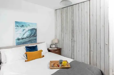 a bed with a tray of fruit on top of it at Parkland Place - Spacious Newquay family holiday home, parking, log burner, dog friendly in Saint Columb Minor