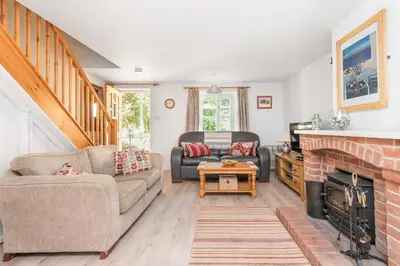a living room with a couch and a fireplace at Chapel Cottage St Mawgan on the Cornish coastline in Saint Mawgan