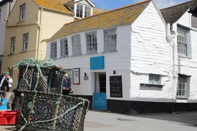 a white building with a sign in front of it at Harbour Loft Port Isaac harbour beach views in Port Isaac