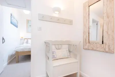 a white room with a mirror and a chair at Harbour Loft Port Isaac harbour beach views in Port Isaac