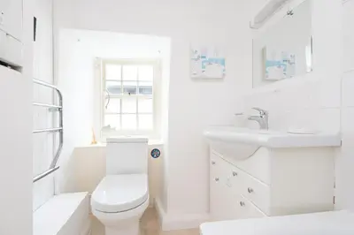 a white bathroom with a toilet and a sink at Harbour Loft Port Isaac harbour beach views in Port Isaac