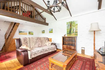 a living room with a couch and a table at Tinners Forge a pretty cottage near Mevagissey in St Austell