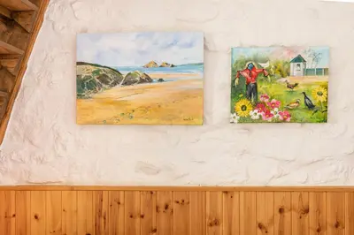 two pieces of art hanging on a wall at Tinners Forge a pretty cottage near Mevagissey in St Austell